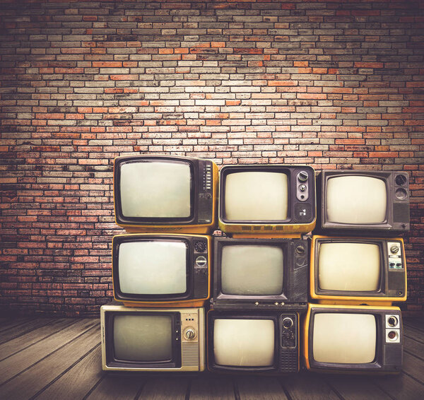 retro televisions pile on floor in old room