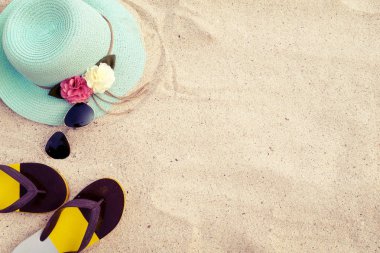 kum tropikal plajındaki şapka, güneş gözlüğü ve flip flop