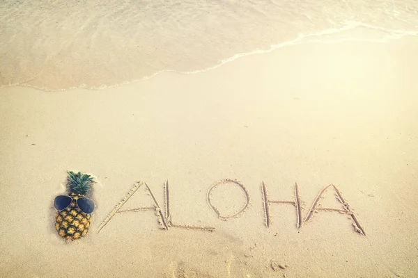 Надпись Алоха написана на песчаном пляже — стоковое фото