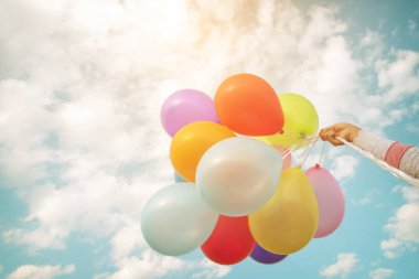 çok renkli balonlar tutan el