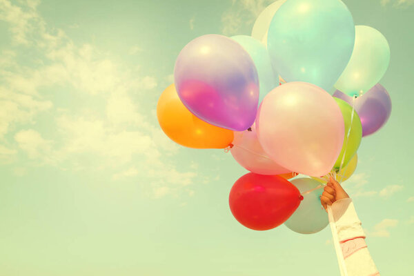 hand holding multicolored balloons