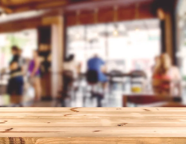 Mostrador de mesa de madera con personas borrosas en la cafetería — Foto de Stock