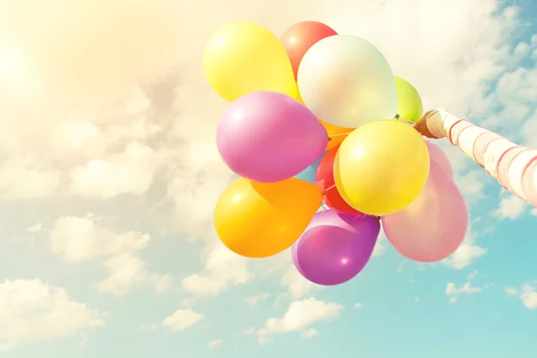hand holding multicolored balloons