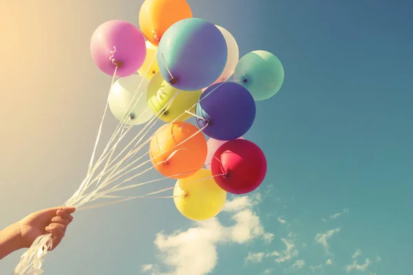 hand holding multicolor balloons