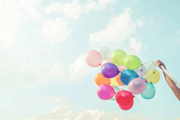 hand holding multicolor balloons