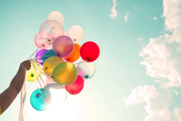 Mão segurando balões multicoloridos — Fotografia de Stock