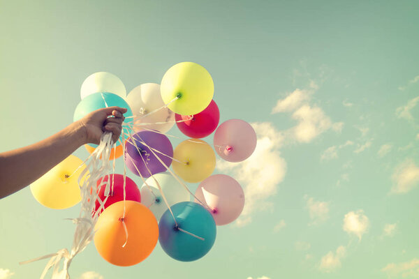 hand holding multicolor balloons