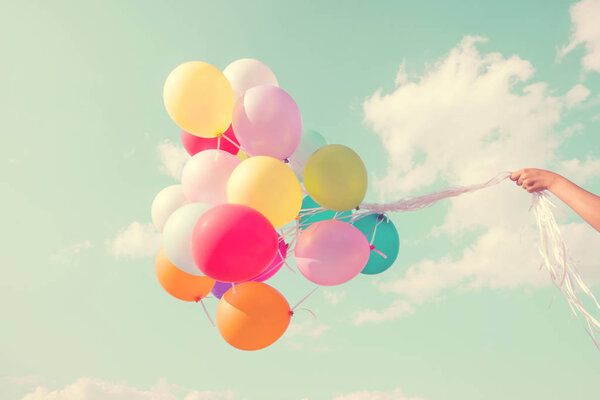 Girl hand holding multicolored balloons