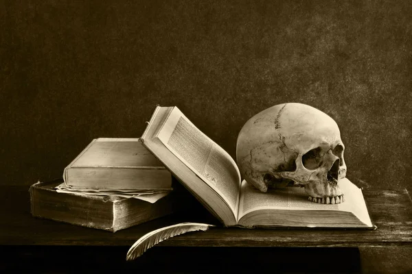 Esqueleto de crânio com livro omn mesa — Fotografia de Stock