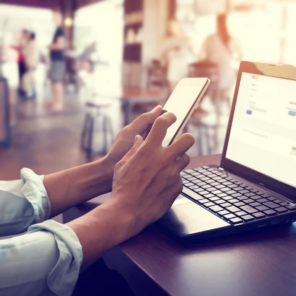  onun laptop çalışma ve akıllı telefon kullanarak iş adamı
