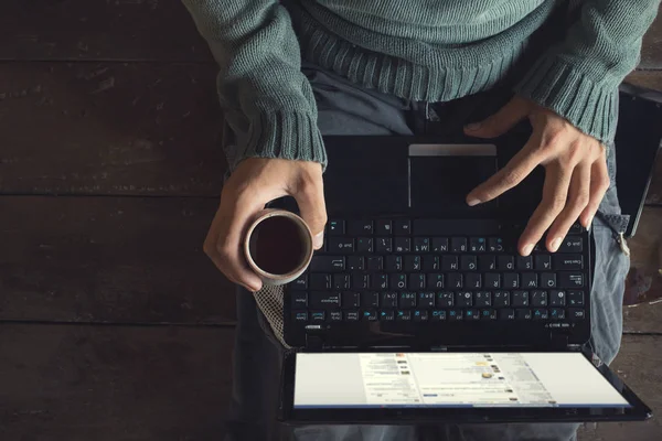 Мужчины руки с помощью ноутбука и чашки кофе — стоковое фото