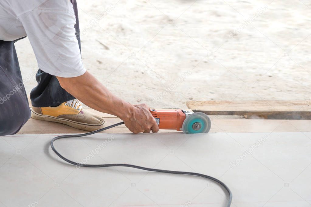  worker  cutting tile with electric saw