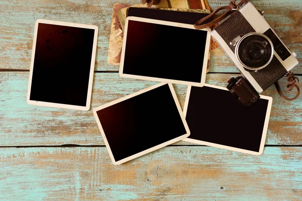 Retro camera and empty old instant paper photo — Stock Photo, Image
