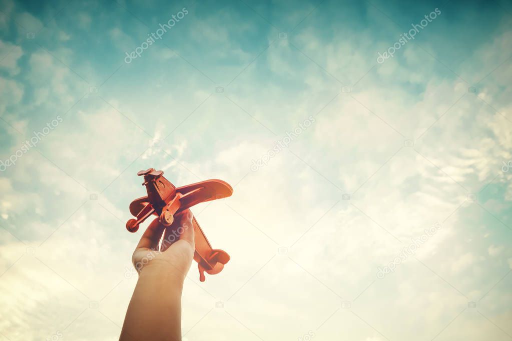 Hands of children holding a toy plane