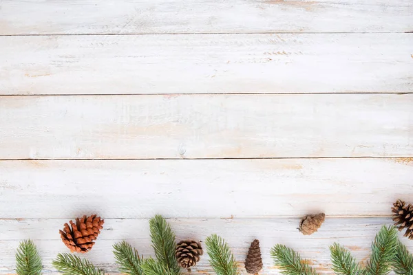 Hojas de abeto y conos de pino elementos decorativos rústicos sobre mesa de madera blanca — Foto de Stock