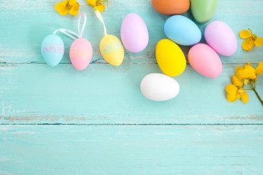 Çiçek rustik ahşap plakalar arka planda mavi boya ile renkli Paskalya yumurtaları. Bahar mevsimi tatil. Vintage pastel renk tonu. Üstten Görünüm kompozisyon.