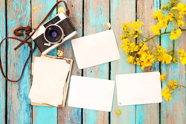 Retro kamera ve çiçek sınır tasarlamak - bahar anma ve nostalji kavramı ile ahşap masa boş eski anlık kağıt fotoğraf albümü. Vintage tarzı