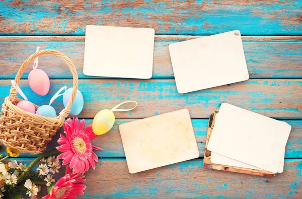 Renkli Paskalya yumurta yuvada çiçek ve ahşap masa - anma ve nostalji tatil kavramı bahar boş eski kağıt fotoğraf albümü ile. Vintage tarzı