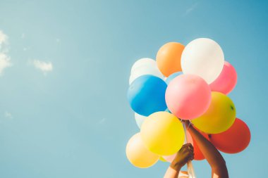 Çok renkli balonlar bir retro instagram filtre efekti, mutlu doğum gün yaz ve balayı düğün, Vintage renk tonu stili kavramı ile yapılan tutan kız el