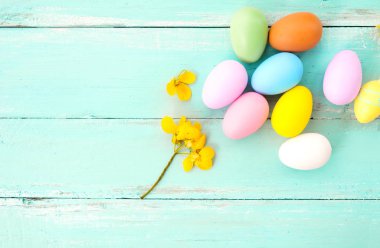 Çiçek rustik ahşap plakalar arka planda mavi boya ile renkli Paskalya yumurtaları. Bahar mevsimi tatil. Vintage pastel renk tonu. Üstten Görünüm kompozisyon.