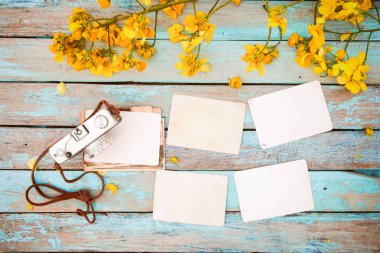 Retro kamera ve çiçek sınır tasarlamak - bahar anma ve nostalji kavramı ile ahşap masa boş eski anlık kağıt fotoğraf albümü. Vintage tarzı