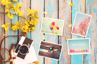 Retro fotoğraf makinesi ve kağıt fotoğraf albümü çiçek sınır tasarlamak - anma ve nostalji tatil kavramı bahar ile ahşap masa üzerinde. Vintage tarzı