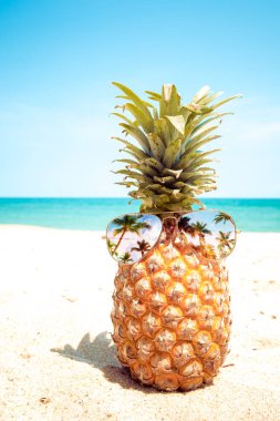 Hipster ananas bir kumlu plajda güneş gözlüklü. yaz moda kavramı. Vintage renk tonu filtre efekti