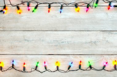 Noel ışıkları ampul çerçeve dekorasyon ahşap beyaz üzerinde. Neşeli Noel ve Yılbaşı tatil arka plan. üstten görünüm