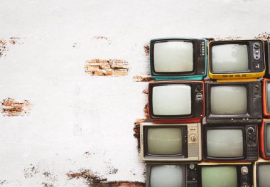 Retro televizyonlar beyaz duvarlı eski odada yere yığıldı. Antika ve antika ev dekorasyonu.