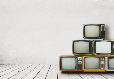 Retro televizyonlar beyaz duvarlı eski odada yere yığıldı. Antika ve antika ev dekorasyonu.