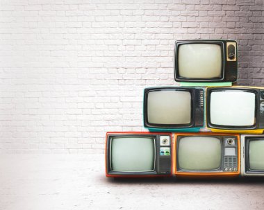 Retro televizyonlar beyaz duvarlı eski odada yere yığıldı. Antika ve antika ev dekorasyonu.