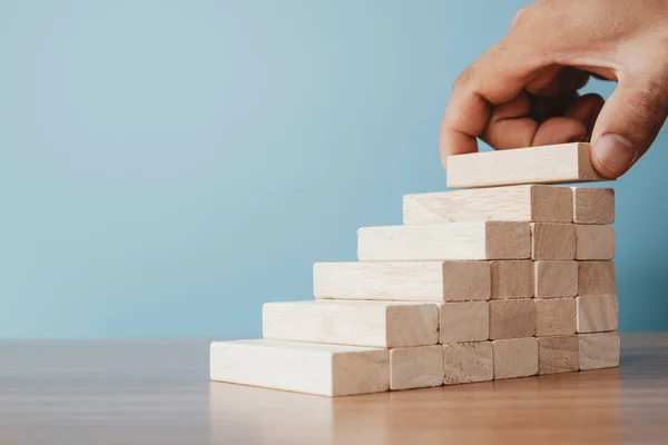 企业理念的阶梯职业道路和成长的成功过程 排木方块堆成台阶的人的手 — 图库照片