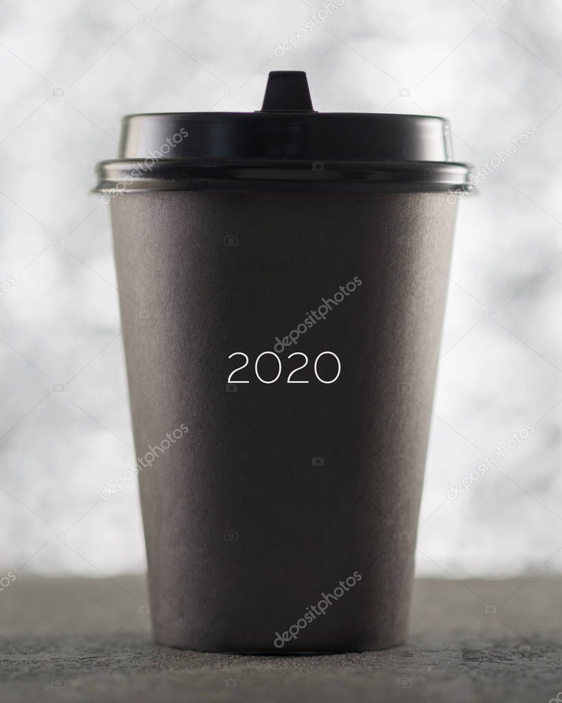 Paper cup coffee, text 2020, festive Christmas background, beautiful blurred bokeh.