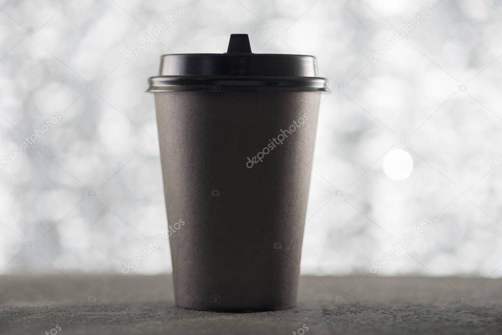 Paper cup of coffee, festive Christmas background, beautiful blurred bokeh, place for text logo.