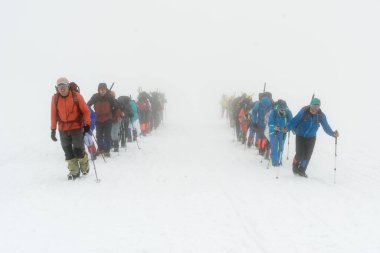 Kafkasya / Rusya - 02 / 06 / 2008 Dağcılık Grubu, Elbrus Dağı 'na tırmanmadan önce dağlarda iklim değiştirme programı. Turistler yüksek karlı dağ zirvelerinin arka planında fotoğraf çekiyorlar.
