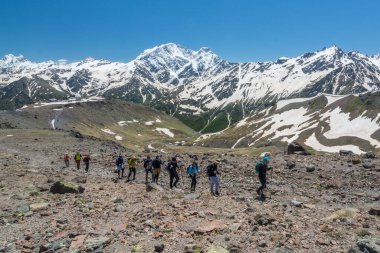 Kafkasya / Rusya - 02 / 06 / 2008 Dağcılık Grubu, Elbrus Dağı 'na tırmanmadan önce dağlarda iklim değiştirme programı. Turistler yüksek karlı dağ zirvelerinin arka planında fotoğraf çekiyorlar.