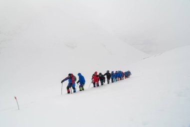 Caucasus / Russia - 07.15.2018 Group of climbers climbing mountain peaks.