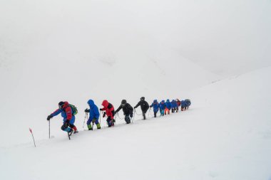 Caucasus / Russia - 07.15.2018 Group of climbers climbing mountain peaks.