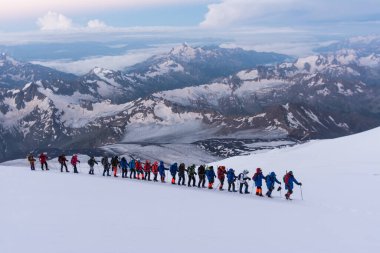 Caucasus / Russia - 07.23.2018 Group of climbers climbing mountain peaks.