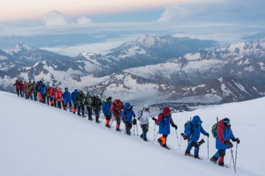Caucasus / Russia - 07.23.2018 Group of climbers climbing mountain peaks.