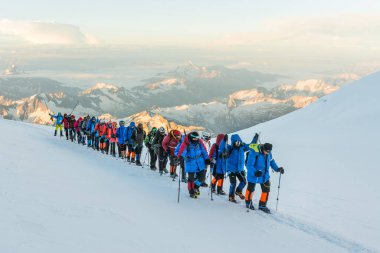 Caucasus / Russia - 07.23.2018 Group of climbers climbing mountain peaks.