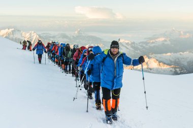 Caucasus / Russia - 07.23.2018 Group of climbers climbing mountain peaks.