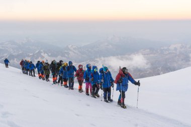 Caucasus / Russia - 07/31/2018 Group of climbers climbing mountain peaks.