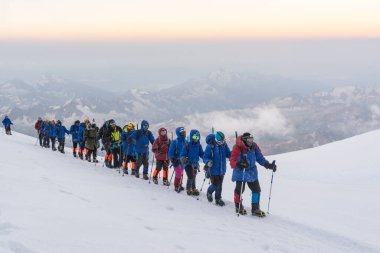 Caucasus / Russia - 07/31/2018 Group of climbers climbing mountain peaks.