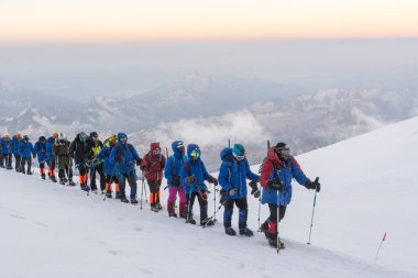 Caucasus / Russia - 07/31/2018 Group of climbers climbing mountain peaks.