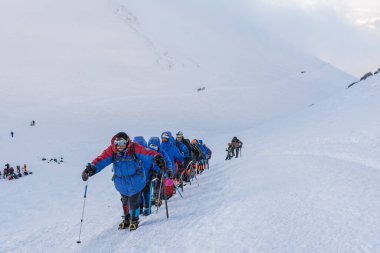 Caucasus / Russia - 07/31/2018 Group of climbers climbing mountain peaks.