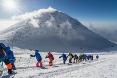 Caucasus / Russia - 07/31/2018 Group of climbers climbing mountain peaks.