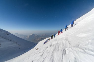 Caucasus / Russia - 07/31/2018 Group of climbers climbing mountain peaks.
