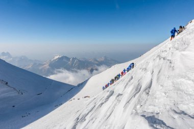 Caucasus / Russia - 07/31/2018 Group of climbers climbing mountain peaks.