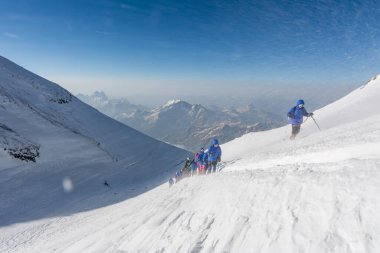 Caucasus / Russia - 07/31/2018 Group of climbers climbing mountain peaks.